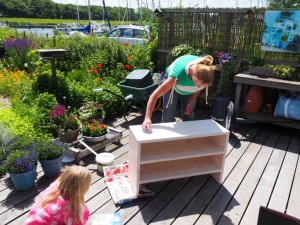 4. Sander heeft in ruil voor twee (wéér die 2!) inflatables een schoenenkastje voor ons getimmerd, waar Joke de laatste verfhand aan legt bij ons in de tuin