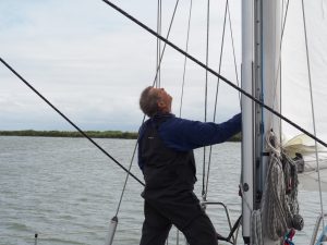 7. The Lady vaart weg zonder motor richting Lelystad. Mathijs kijkt of het nieuwe grootzeil er strak bij staat