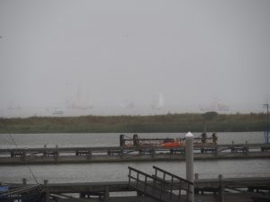 27. Buitengaats is het grauw van de regen, waardoor de vloot nog amper te zien is vanaf het havenhoofd waar ik met mijn camera sta