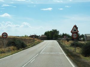 52. En aan de andere kant van deze weg staat een bord met de nieuwe auto's. De koe op het bord is écht een Spaanse koe! Kort op de pootjes. Daar hoeft geen emmer onder!!!